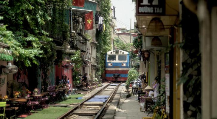 Un train roulant sur une voie entourée d'habitations et de commerces